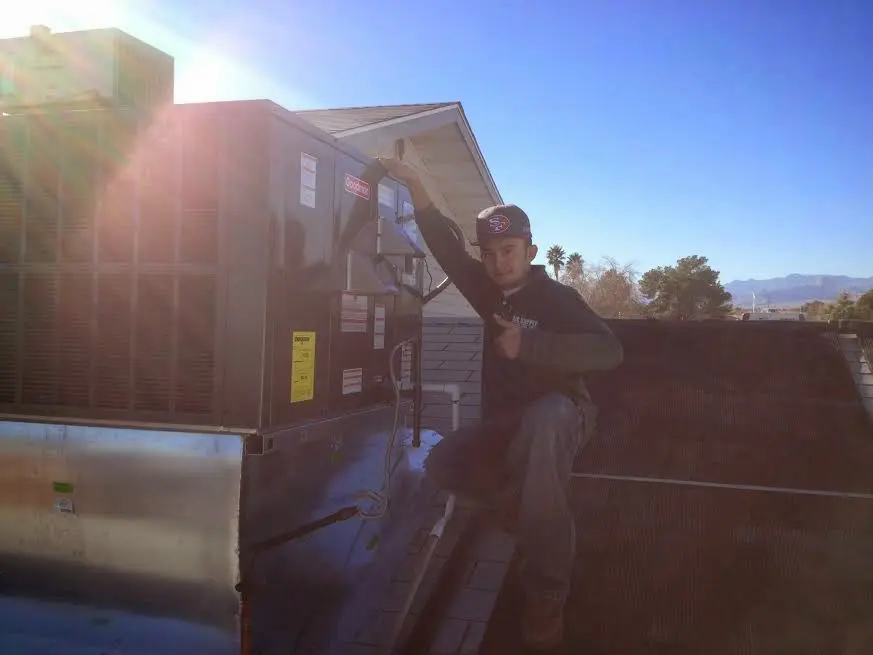 HVAC technician performing HVAC Inspection on a rooftop unit in Forest Park